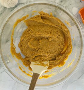 bowl of pumpkin batter with a spatula.