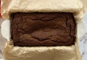 baked pumpkin bread in a parchment lined loaf pan.