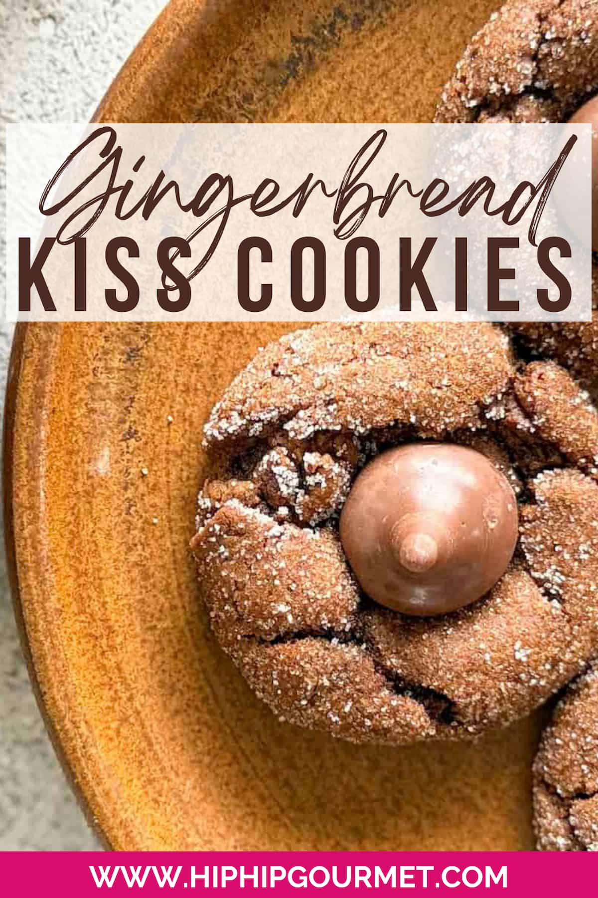 close up of a brown gingerbread cookie rolled in sugar with a hershey kiss on top.