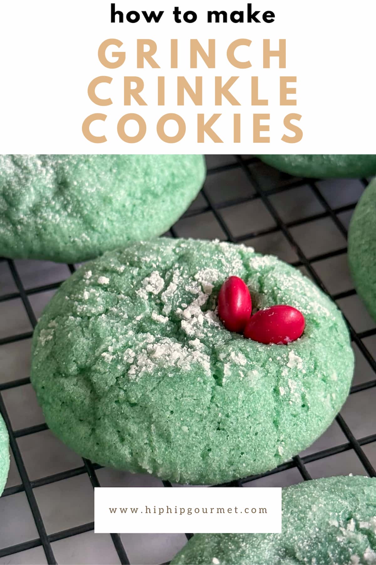close up of a green crinkle cookie on a wire rack with 2 red m&m's pressed into the top right to look like a heart. more cookies surrounding.