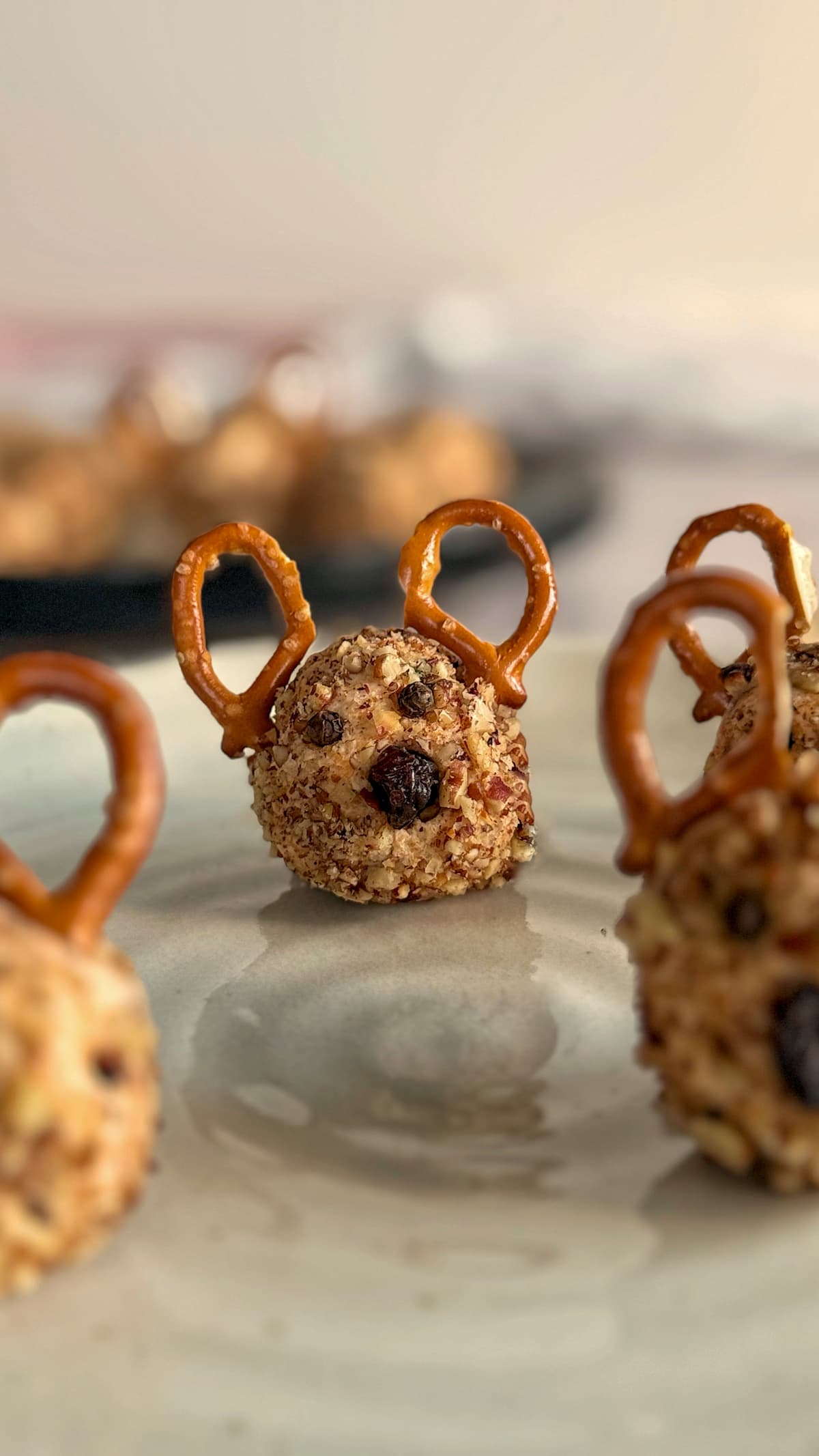mini reindeer cheese ball on a plate with more, plus more in the background.