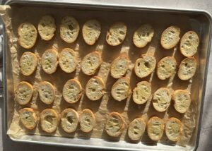 toasted baguette sliced on a parchment lined baking sheet.