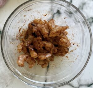 raw seasoned shrimp in a bowl.
