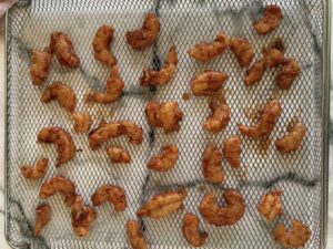 seasoned shrimp on an air fryer tray.