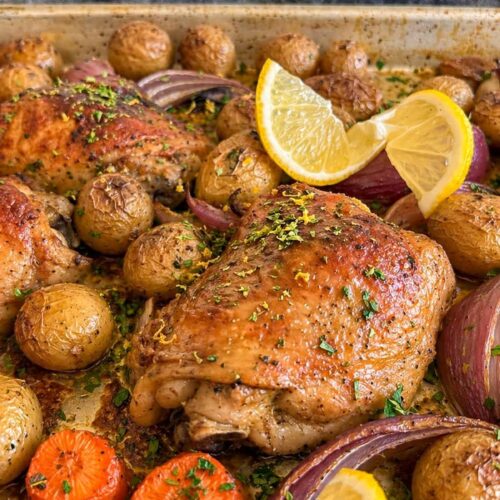 chicken and lemon tray bake with potatoes, red onions, and carrots.