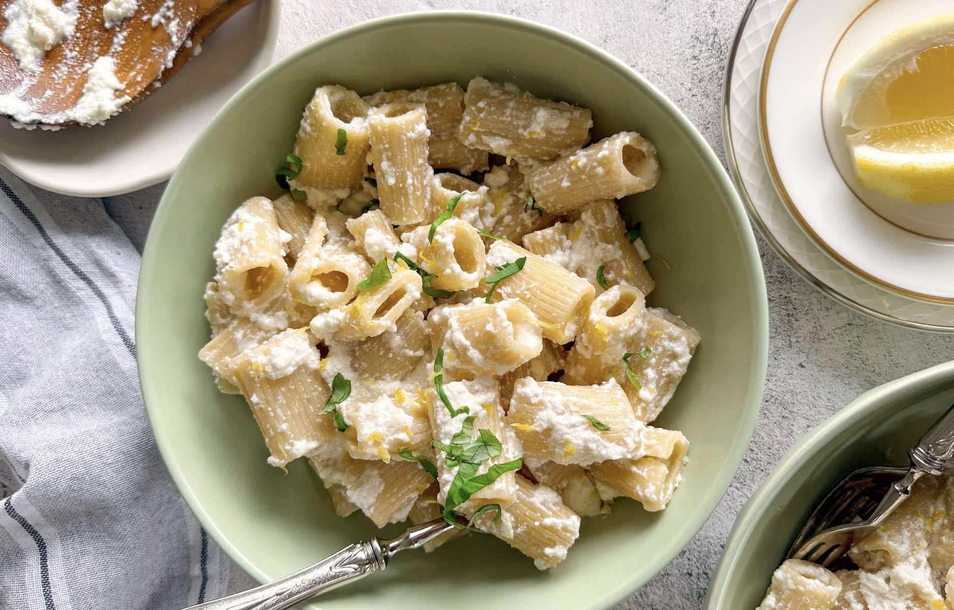 lemon and ricotta pasta in a bowl topped with fresh basil and lemon zest.