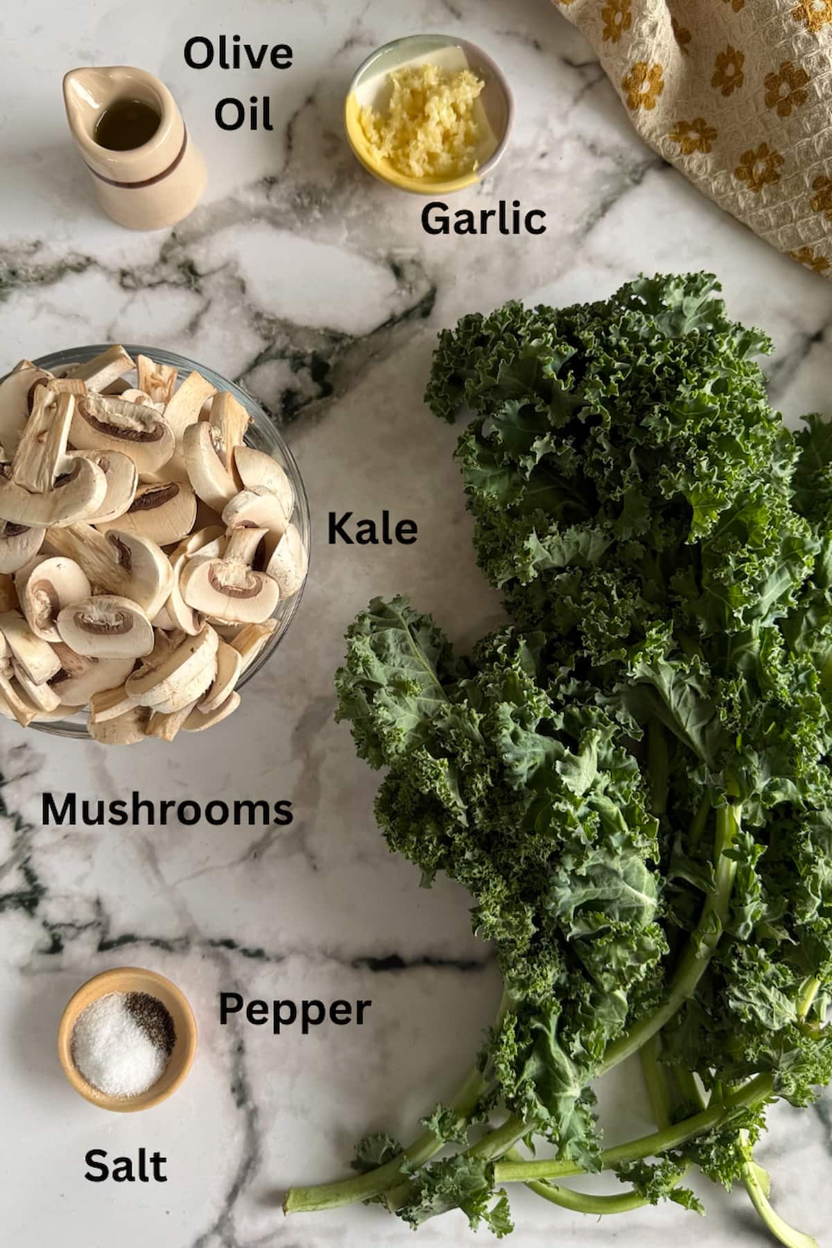 ingredients to make sauteed kale and mushrooms - sliced mushrooms, bunch of kale, olive oil, minced garlic, salt, and pepper.