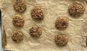 8 baked 4 ingredient banana oatmeal cookies on a parchment lined baking sheet.