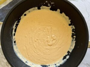 thick orange cheese sauce in a black pan.