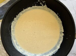 creamy thick white sauce in a black deep skillet.