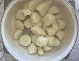 cooked potato chunks steaming in a pot.