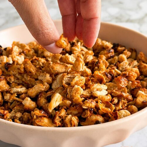 hand grabbing some crispy white beans out of a bowl.