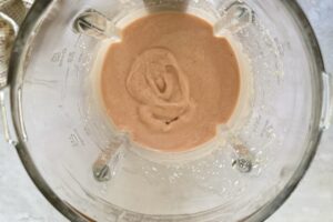 pink/orange-ish smoothie in a blender.