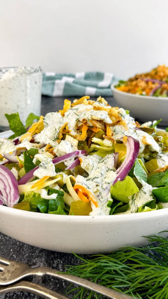 Chopped dill pickle salad with romaine lettuce, dill pickle ranch dressing, shredded cheese, red onion, and chopped pickles.