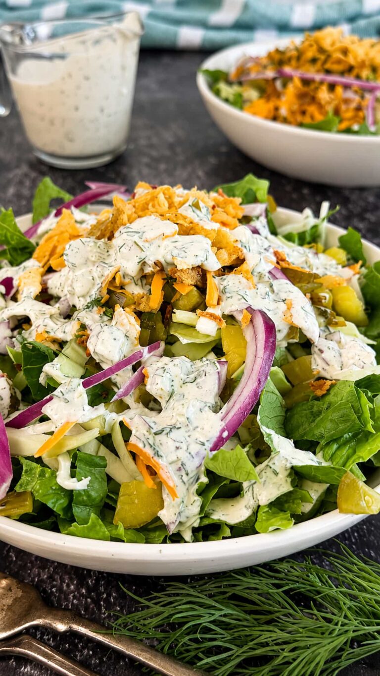 Chopped dill pickle salad with crisp romaine, pickles, red onion, cheddar cheese, and creamy dill dressing.