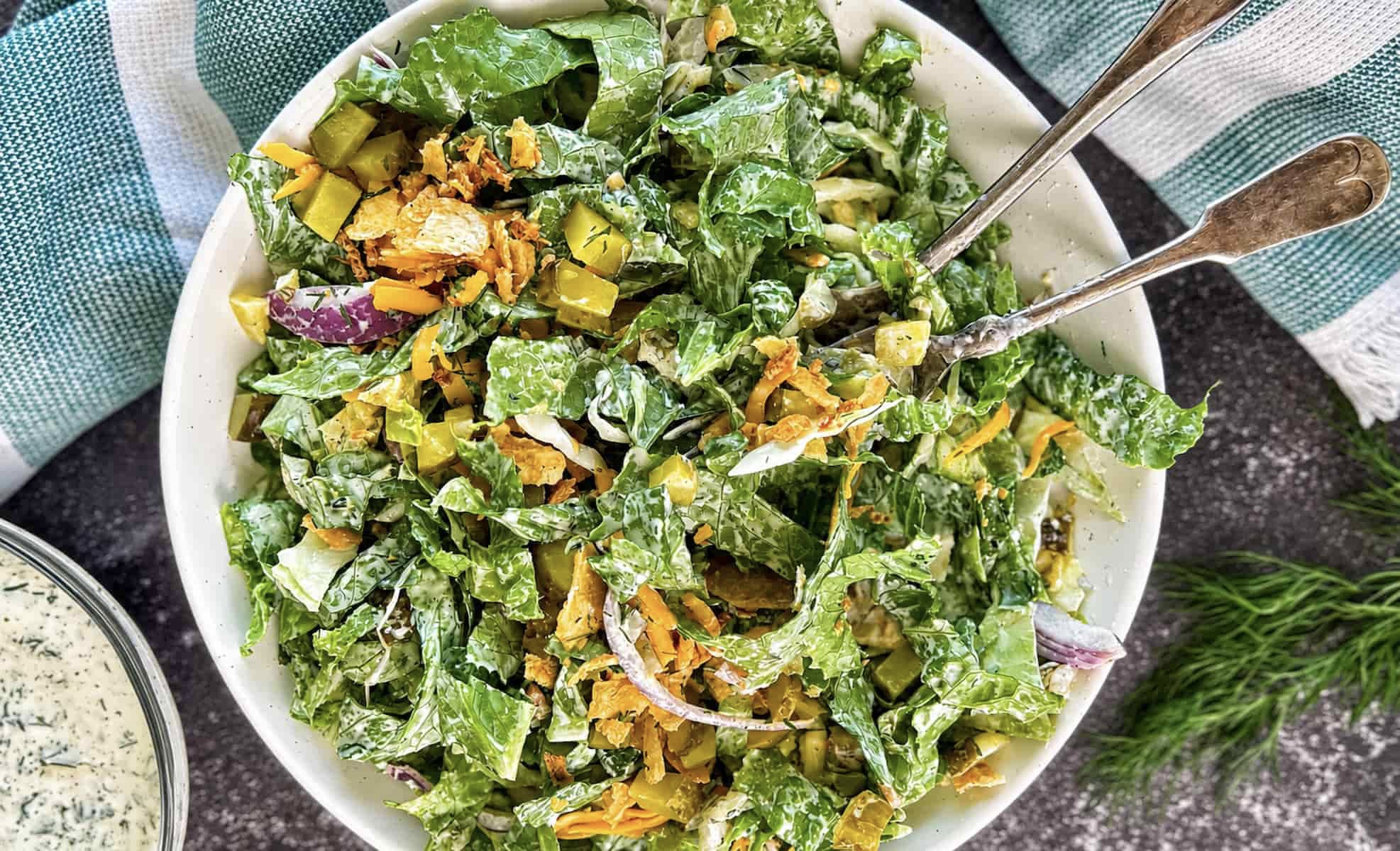 Tossed chopped dill pickle salad with romaine lettuce, chopped pickles, shredded cheese, crispy onions, and creamy dill pickle ranch dressing.