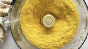 freshly blended smooth mango orange sorbet in the base of a food processor.