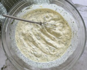 bowl of dill mayo with a little whisk.