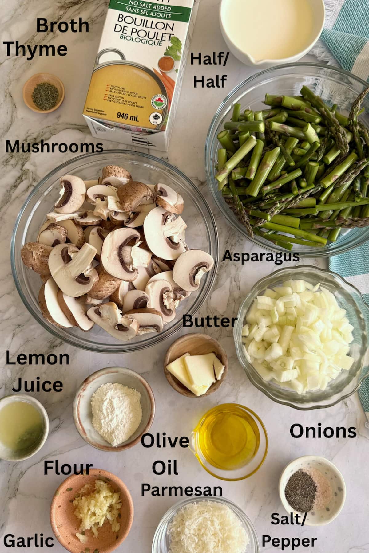 ingredients for asparagus and mushrooms soup - broth, thyme, mushrooms, asparagus, half and half, butter, olive oil, salt, pepper, garlic, flour, parmesan, onions, and lemon juice.