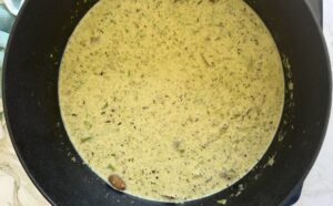 creamy asparagus and mushroom soup in a black pot.