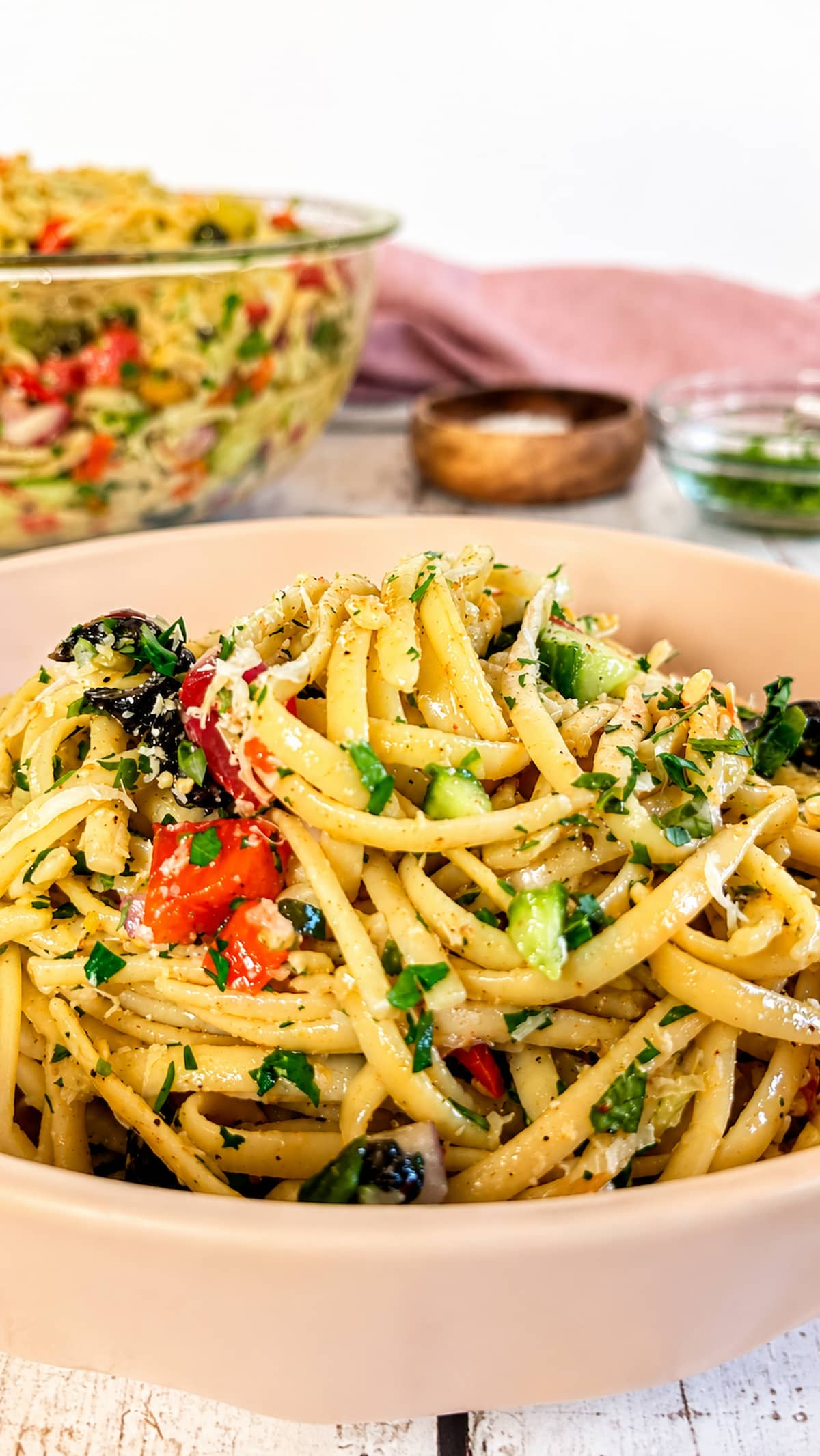 Linguine pasta salad with cherry tomatoes, black olives, cucumber, fresh parsley, and Parmesan cheese.