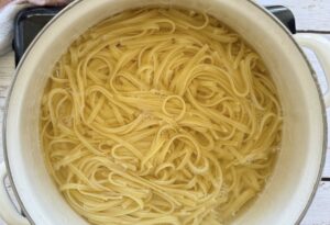 linguine cooking in a pot of water.