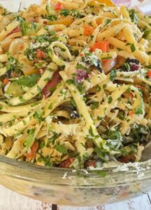linguine pasta salad with vegetables, parsley, and parmesan cheese.