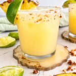 Pineapple coconut margarita with fresh pineapple, lime, and a toasted coconut salt rim.
