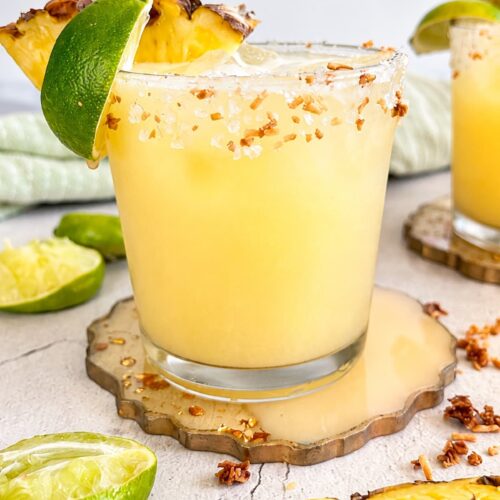 Pineapple coconut margarita with fresh pineapple, lime, and a toasted coconut salt rim.