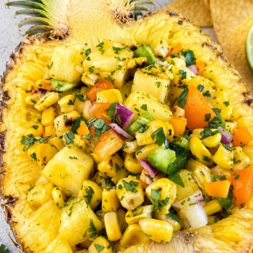 Pineapple corn salsa with fresh pineapple, charred corn, peppers, red onion, and cilantro served in a pineapple bowl.