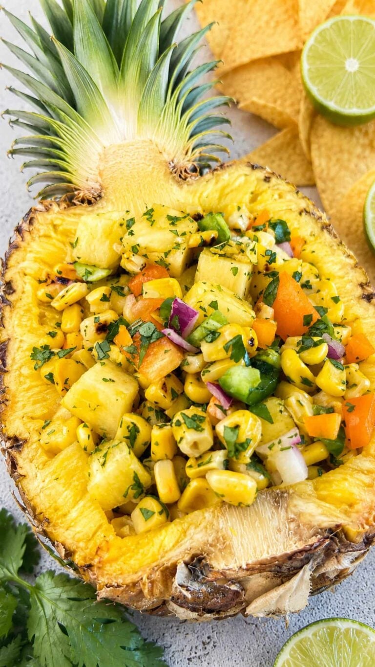 Pineapple corn salsa with fresh pineapple, charred corn, peppers, red onion, and cilantro served in a pineapple bowl.