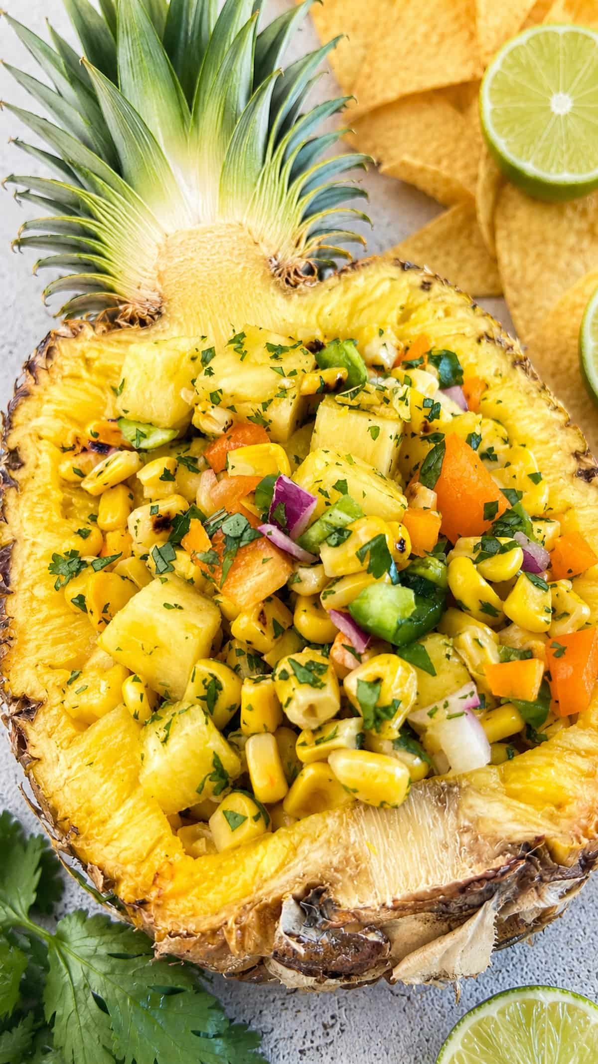 Pineapple corn salsa with fresh pineapple, charred corn, peppers, red onion, and cilantro served in a pineapple bowl.
