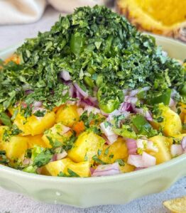 bowl of diced pineapple, red onions, and lots of chopped cilantro on top.