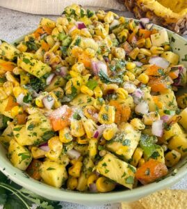pineapple corn salsa with bell pepper, red onions, cilantro, and salt in a bowl.