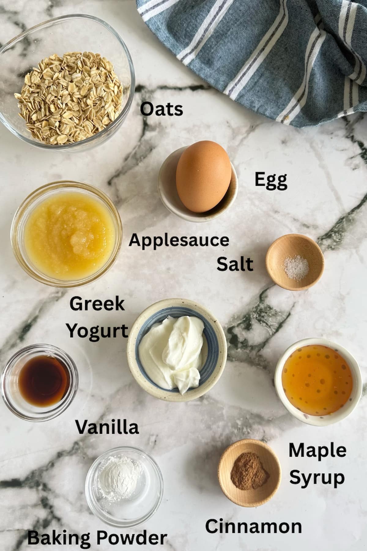 ingredients for baked oats without banana - oats, egg, applesauce, baking powder, cinnamon, maple syrup, greek yogurt, vanilla, and salt.