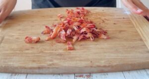 chopped cooked bacon on a cutting board.