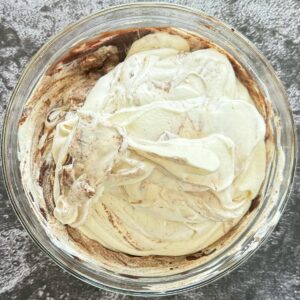 bowl of whipped cream on top of a chocolate pudding base.