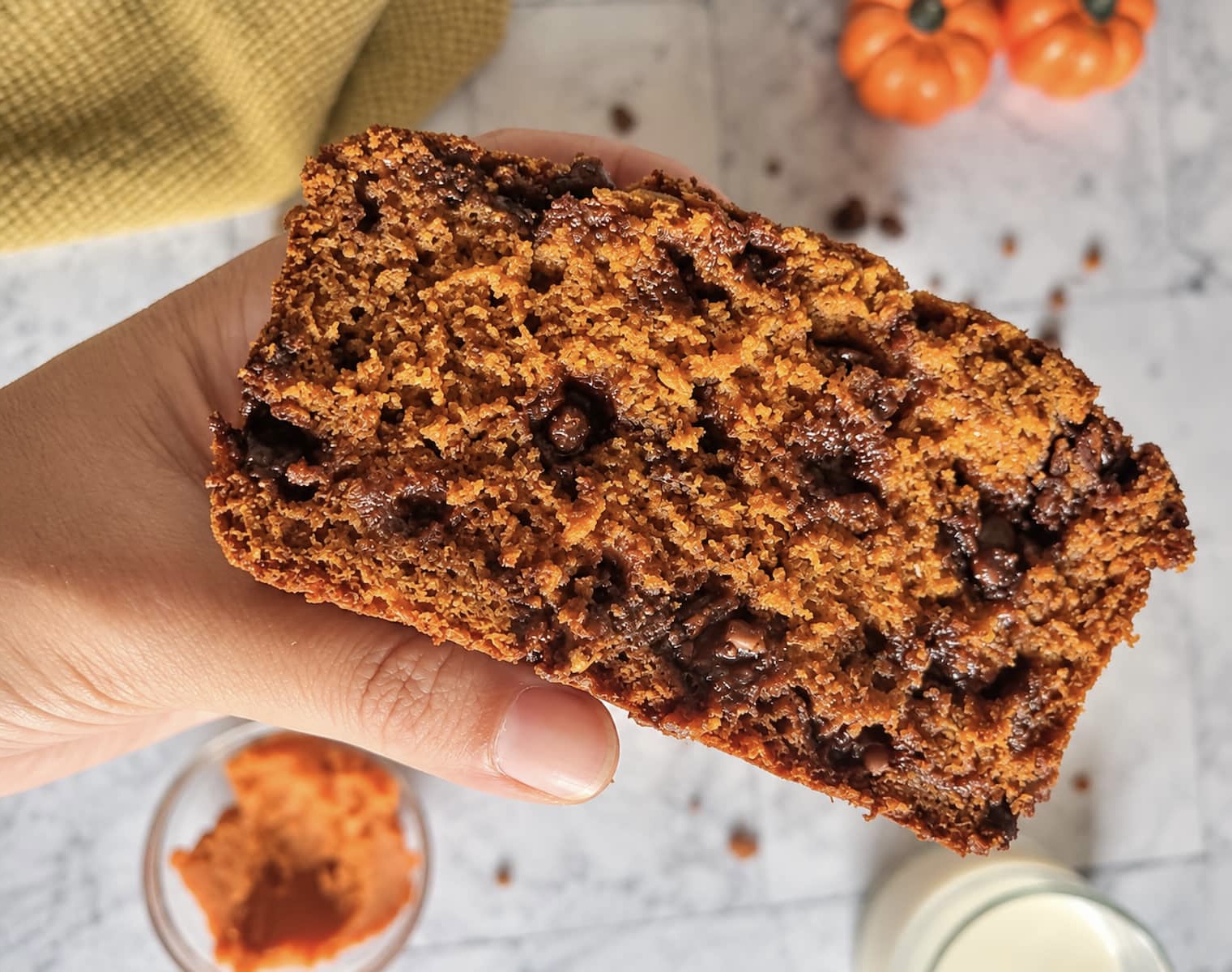 Pumpkin chocolate chip bread slice with a moist pumpkin crumb and melty chocolate chips.