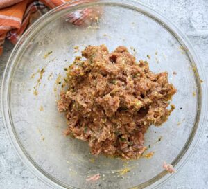 raw pumpkin meatball mixture in a glass bowl.