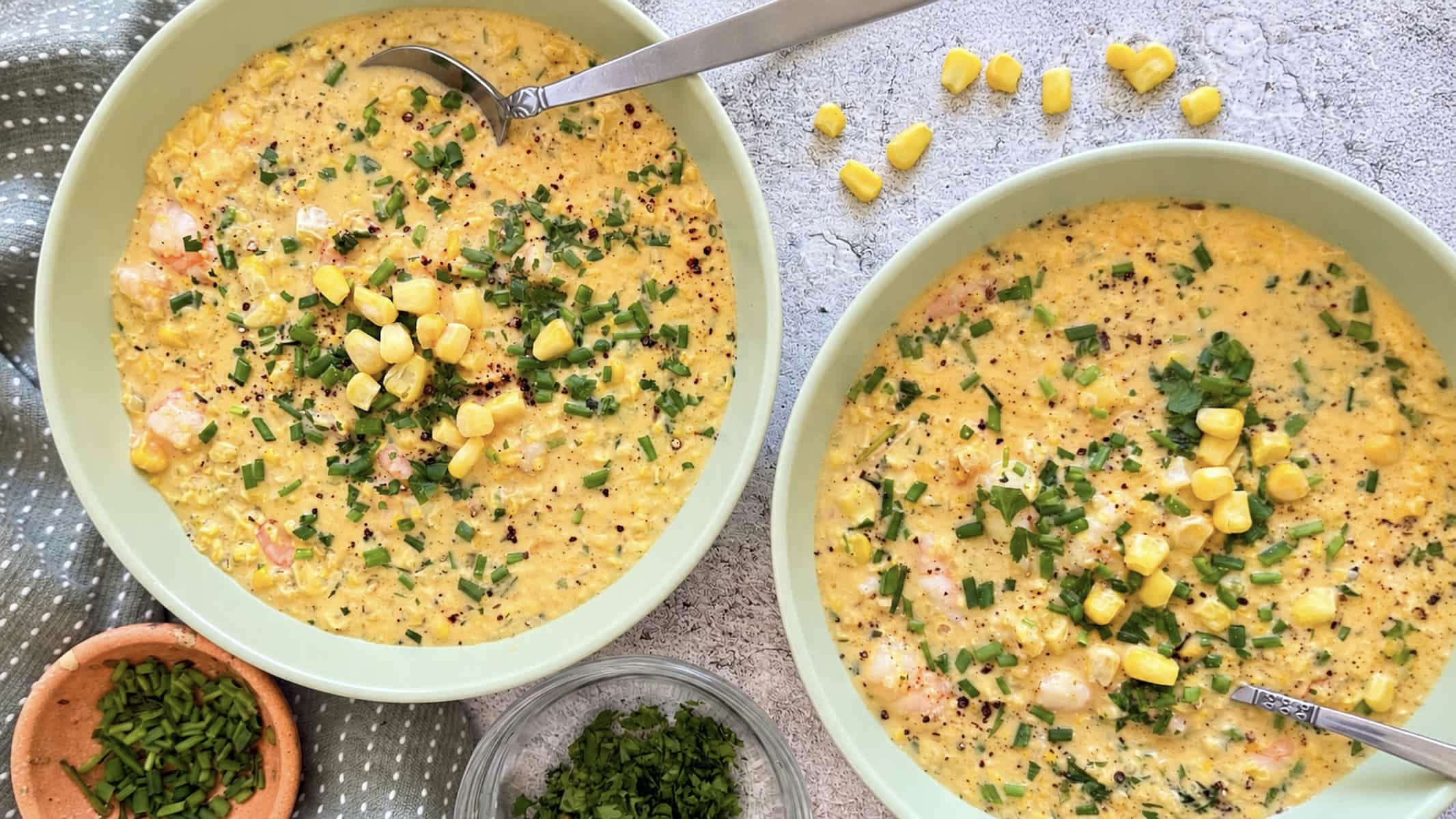 Creamy shrimp and corn chowder topped with sweet corn, fresh chives, herbs, and black pepper.