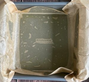 greased square baking pan with a piece of parchment over top.
