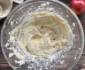 whipped cream cheese frosting in a large glass bowl.