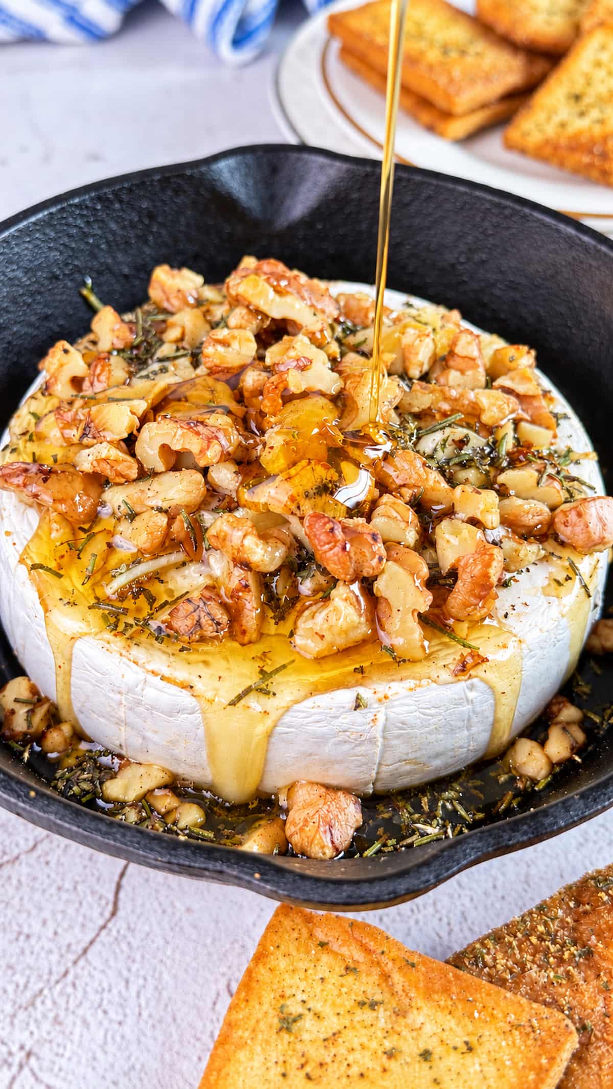 Honey baked Camembert topped with walnuts and herbs, drizzled with golden honey and served with toasted bread.