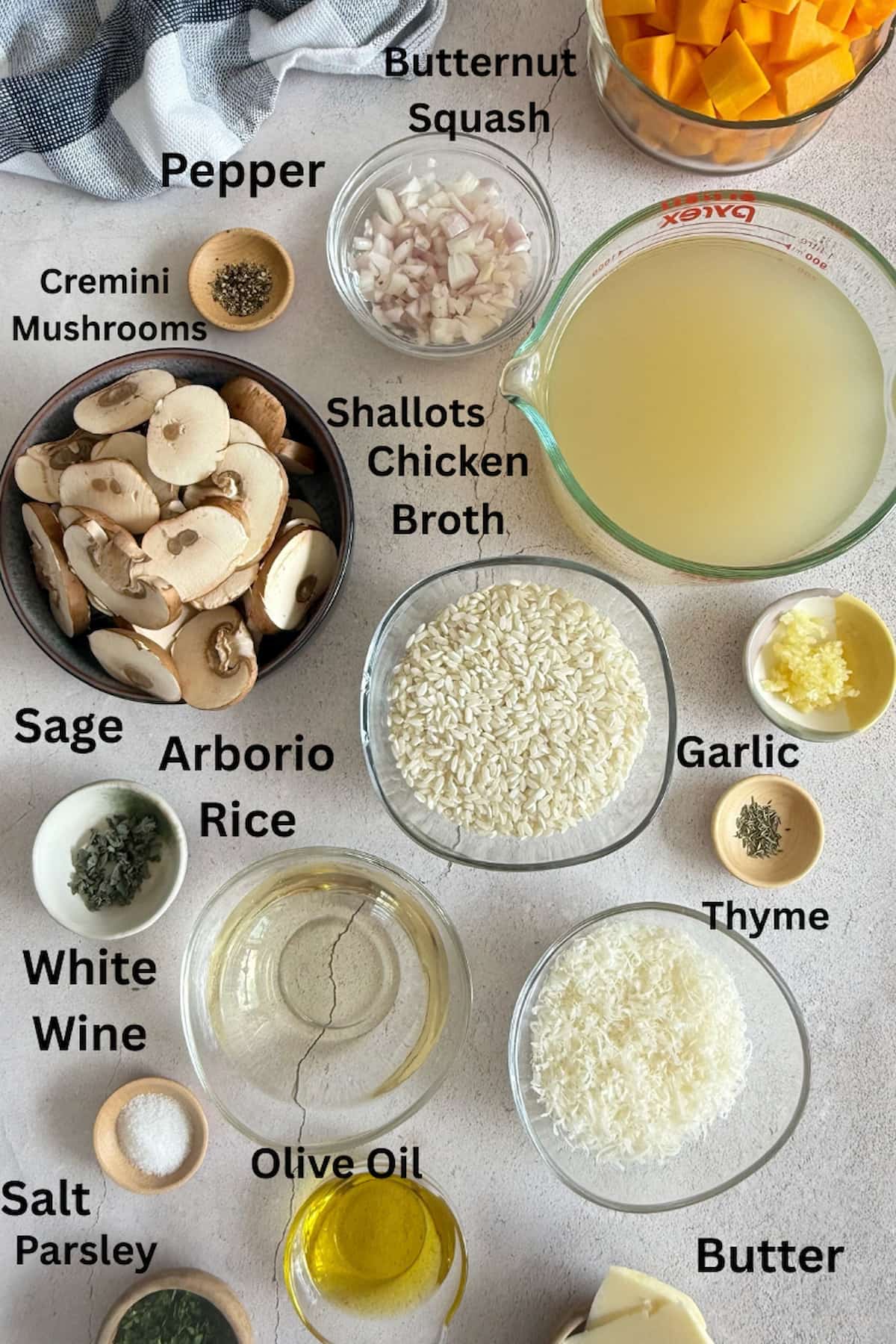 ingredients for butternut squash mushroom risotto - butternut squash, cremini mushrooms, chicken broth, shallots, salt, pepper, thyme, sage, parsley, parmesan, olive oil, butter, garlic, white wine, and arborio rice.