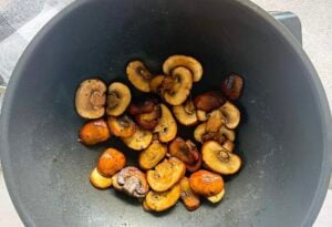 golden brown cremini mushrooms in a wok.