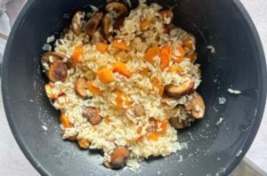 butternut squash and mushroom risotto in a wok.