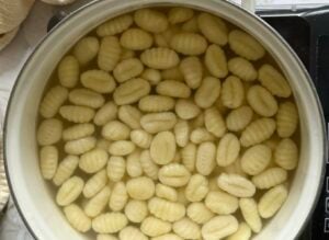 gnocchi cooking in a pot of water.