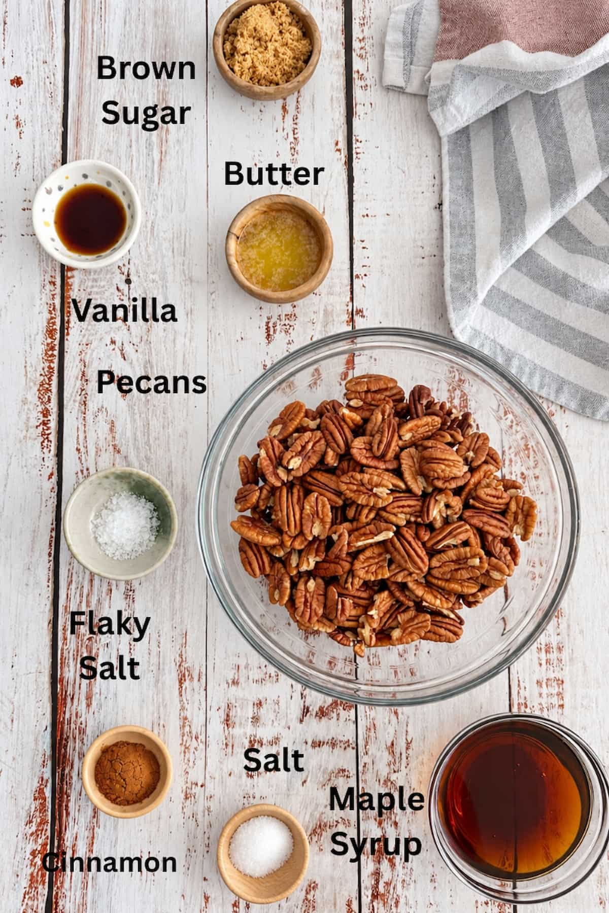 Ingredients for homemade maple glazed pecans, including pecan halves, maple syrup, brown sugar, melted butter, vanilla, cinnamon, and salt.