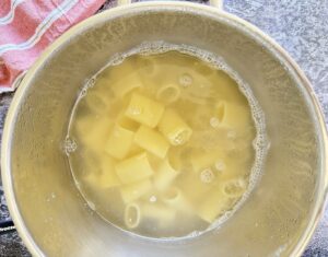 rigatoni pasta cooking in a pot of water.