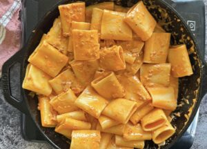 creamy rigatoni nduja pasta in a cast iron skillet.